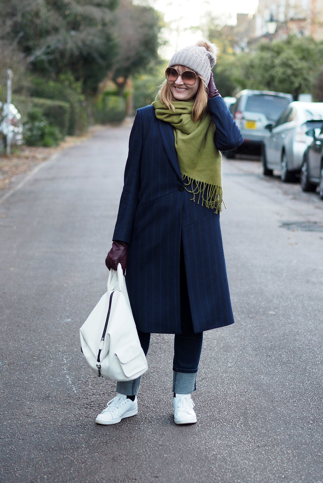 Smart cold weather layered outfit navy pinstripe wool coat moss green wool scarf bobble hat white backpack and Adidas Stan Smiths deep hem straight leg jeans | Not Dressed As Lamb, over 40 style