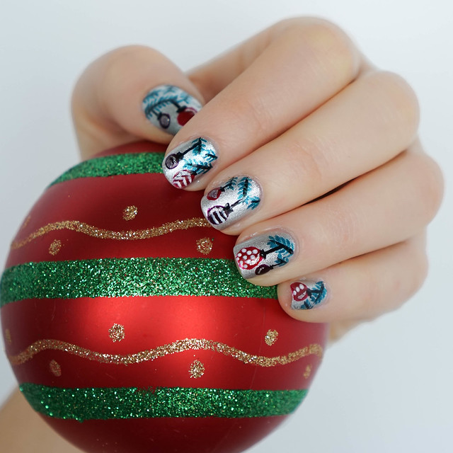 woman showing Christmas Ornament Nail Art and holding Christmas ball