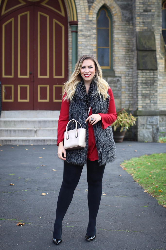 woman wearing Holiday Red Romper and Gray Fur Vest for Christmas Outfit Inspiration
