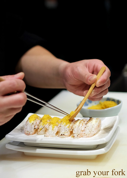 Sushi chef Tomoyuki Matsuya adding karasumi dried mullet roe to seared scampi at Hana Ju-Rin in Crows Nest Sydney