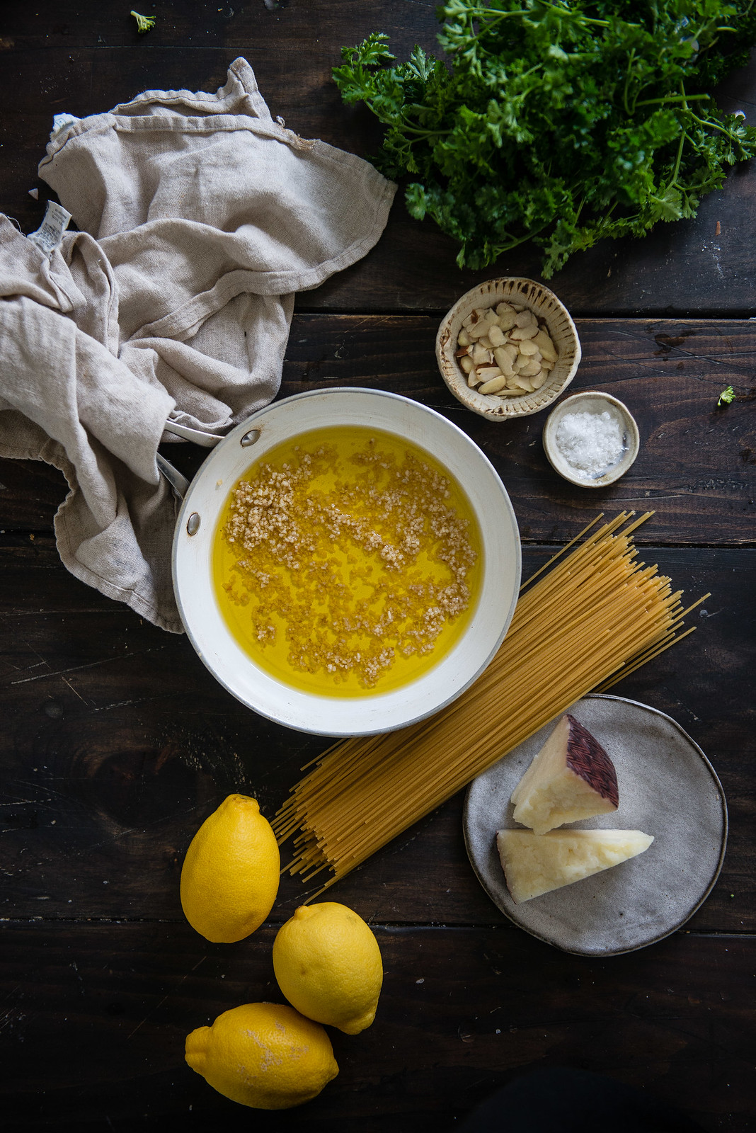 garlicky spaghetti with lemon, capers, & almonds | two red bowls