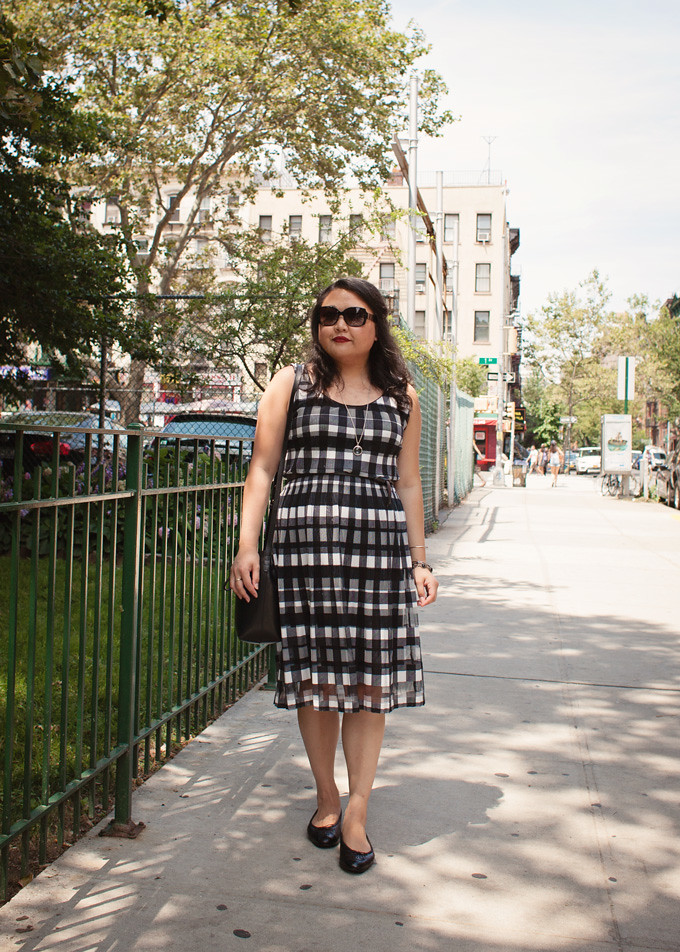 wearing a black and white gingham dress