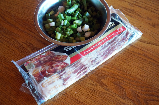 A bowl of chopped scallions and a package of cherrywood-smoked bacon: seasonings of champions