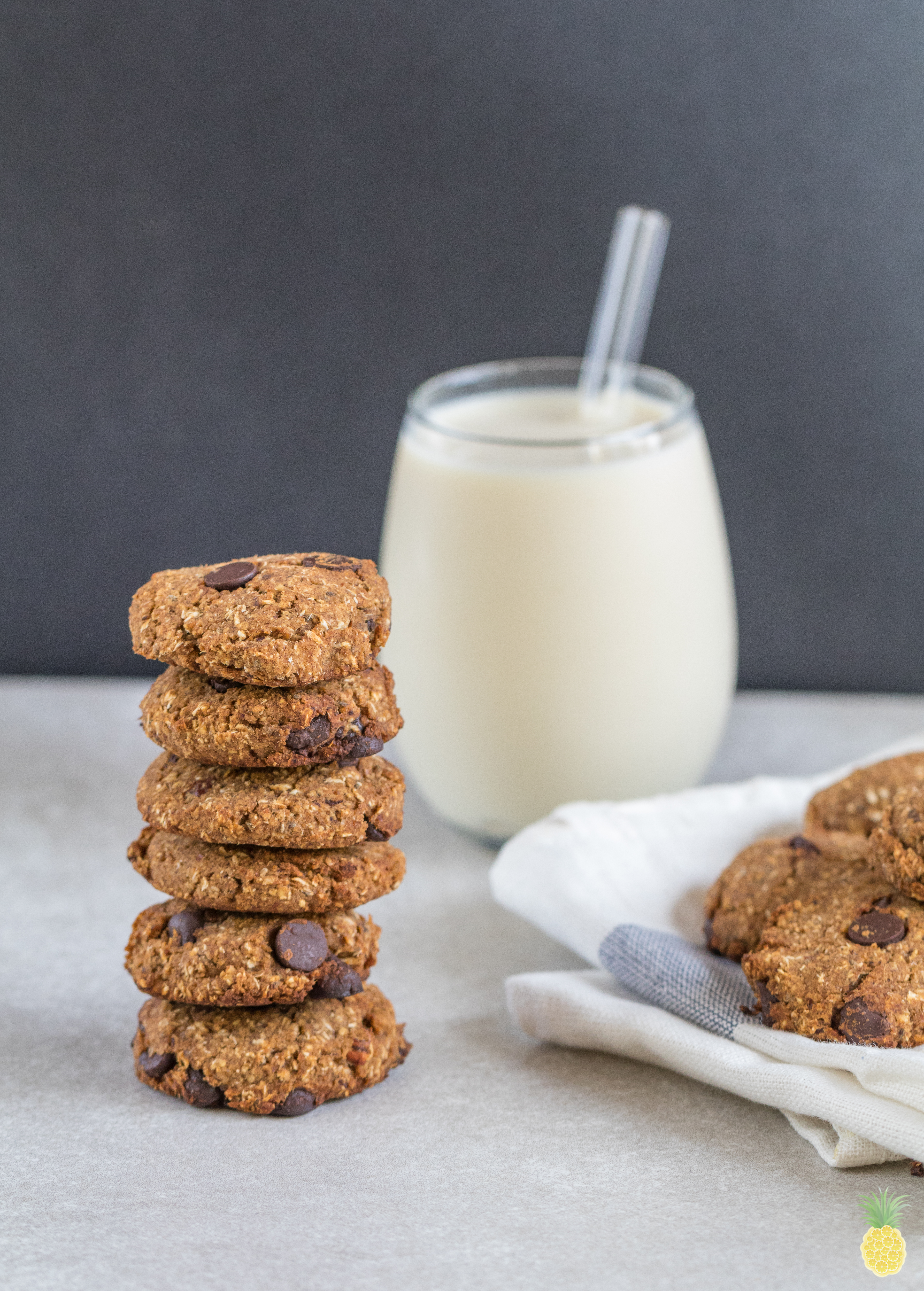 A stack of vegan chickpea cookies in front of a glass of milk and a blue towel on sweetsimplevegan.com